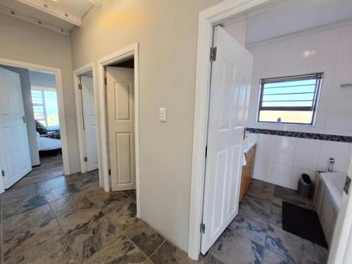 a bathroom with a tub and a sink and a window at Barefoot Bliss Holiday Home in Port Alfred