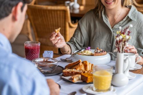 Una mujer sentada en una mesa con un hombre comiendo comida en La Quinta Menorca by PortBlue Boutique - Adults Only, en Cala'n Bosch