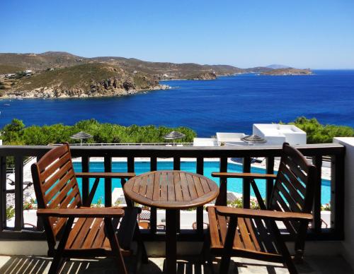 a table and chairs on a balcony with a view of the ocean at Patmos Paradise Hotel in Kámbos