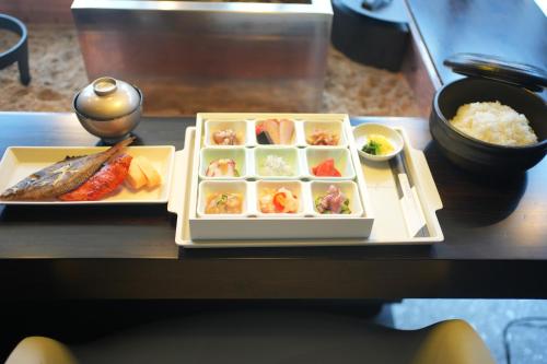 awaJ Beach Club アワジェイビーチクラブ في Awaji: صينية طعام مع السوشي والأرز على طاولة