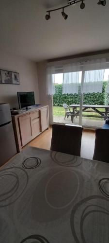- un salon avec une table et une vue sur un patio dans l'établissement Appartement T2 cabine Berck rez de jardin parking, à Berck-sur-Mer