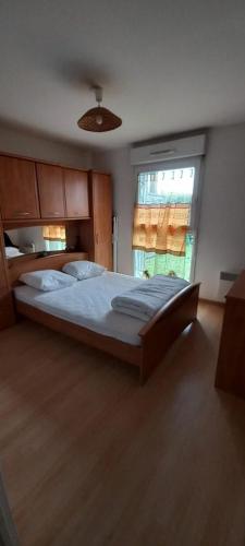 une chambre avec un grand lit et une fenêtre dans l'établissement Appartement T2 cabine Berck rez de jardin parking, à Berck-sur-Mer