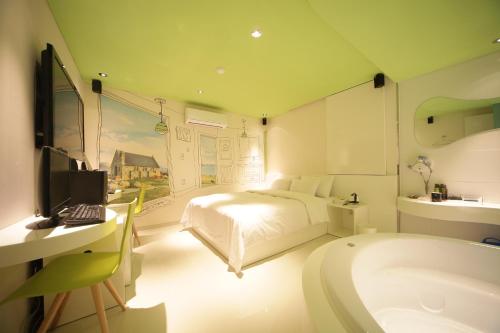 a bedroom with a bed and a bathroom with a tub at Jongno Hotel Pop Leeds Premier in Seoul