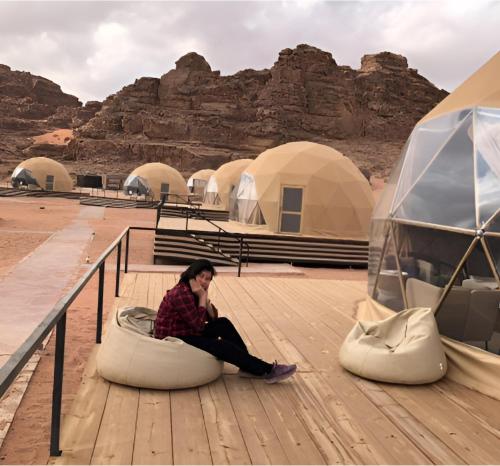 a woman sitting on a bean bag in the desert at Rum rose luxury camp in Wadi Rum
