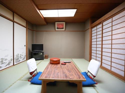 a room with a wooden table and two chairs at Takao Kanko Hotel in Kyoto
