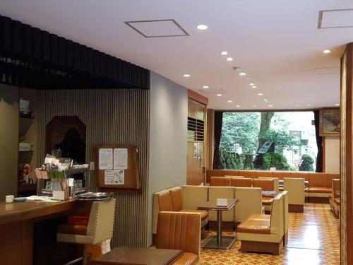 a waiting room with chairs and tables and a window at Takao Kanko Hotel in Kyoto