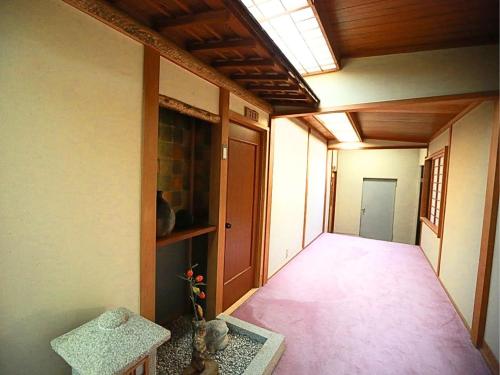 an empty hallway of a house with a table at Takao Kanko Hotel in Kyoto