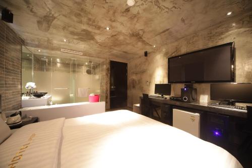 a hotel room with a bed and a television at Jongno Hotel Pop Leeds Premier in Seoul