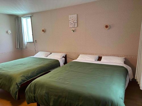 two beds sitting next to each other in a room at I LOVE HAKONE in Hakone