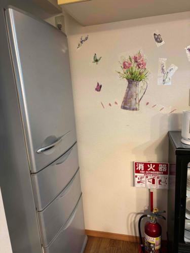 a refrigerator in a kitchen with butterflies on the wall at I LOVE HAKONE in Hakone