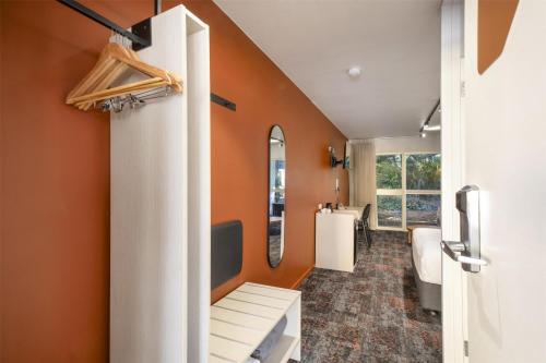 baño con paredes de color naranja y espejo en Nightcap at Dalrymple Hotel, en Townsville
