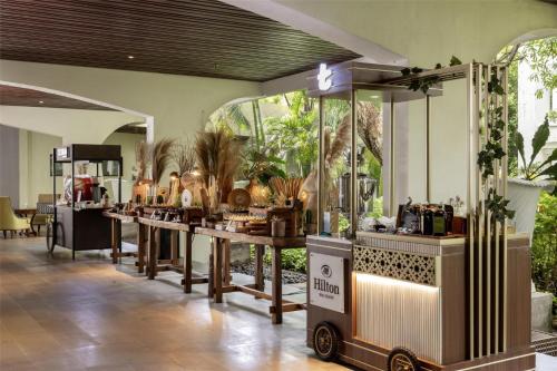 a room with a counter with tables and plants at Hilton Bali Resort in Nusa Dua