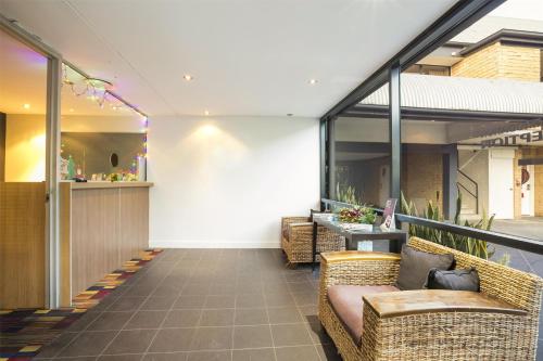 a lobby with wicker chairs and a table at Nightcap at Kawana Waters Hotel in Kawana Waters