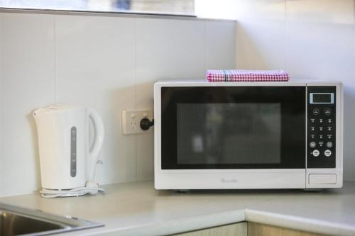 a microwave sitting on top of a kitchen counter at Nightcap at Kawana Waters Hotel in Kawana Waters