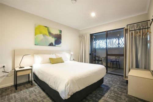 a hotel room with a bed and a balcony at Nightcap at Kawana Waters Hotel in Kawana Waters