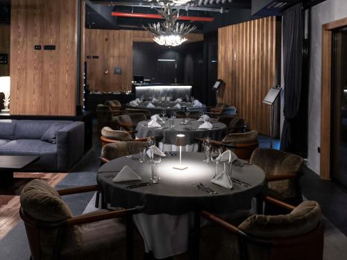 a restaurant with tables and chairs and a chandelier at Swissôtel Resort Kolasin in Kolašin