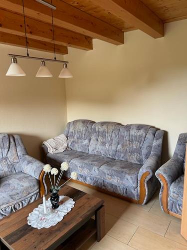 a living room with two couches and a coffee table at Ferienwohnung Christa in Hähnichen