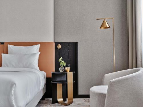 a hotel room with a bed and a chair at Mövenpick Grand Hotel Wroclaw in Wrocław
