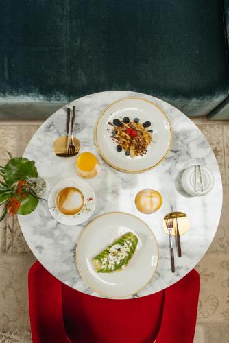 a white table with plates of food on it at Casa de las Artes, member of Meliá Collection in Madrid