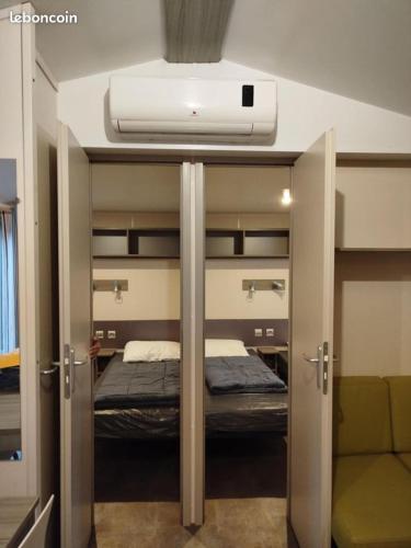 - une petite chambre avec un lit et une publicité dans l'établissement mobil-home 6 couchage sur la côte landaise, à Lit-et-Mixe