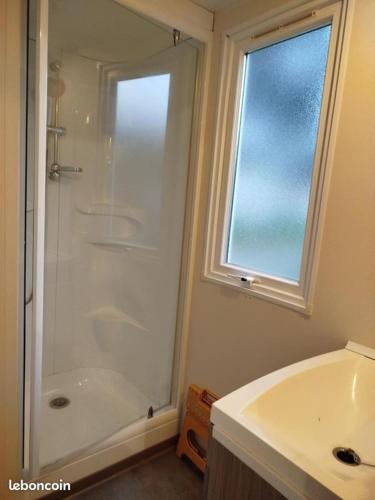 une salle de bain avec une douche et un lavabo et une fenêtre dans l'établissement mobil-home 6 couchage sur la côte landaise, à Lit-et-Mixe