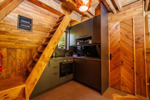 a kitchen with wooden walls and a staircase in a house at Woodland Brezna in Pluzine