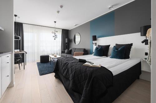 a bedroom with a large bed with a blue wall at Sky Hotel City Apartments in Linköping