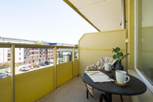 a small table on a balcony with a view of a city at Sky Hotel City Apartments in Linköping