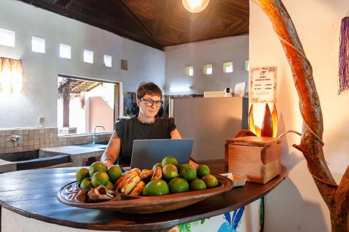 a man sitting at a table with a laptop at A casa di Giorgia lodge Nosy be Andilana in Nosy Be