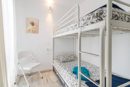 a bedroom with two bunk beds and a chair at Stunning & Stylish Apartment In Cadaqués in Cadaqués