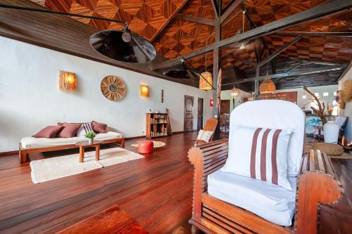 a living room with a couch and a chair at A casa di Giorgia lodge Nosy be Andilana in Nosy Be