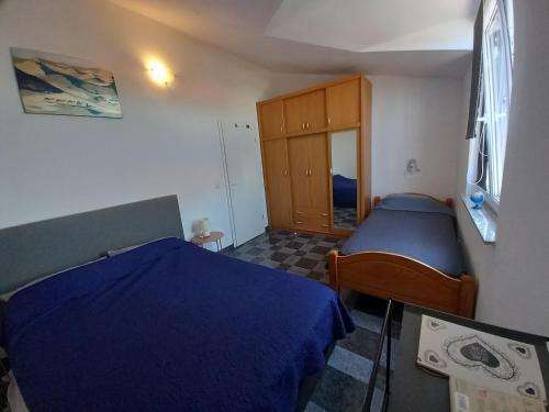 a small bedroom with two beds and a cabinet at Apartman Renata in Pula