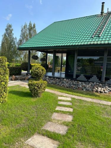 a stone path in front of a building with a green roof at Brīdis Sev in Ķekava