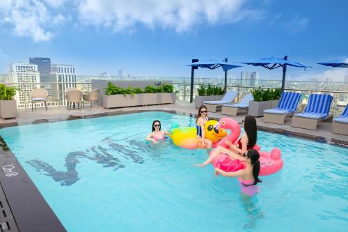 a group of women in a swimming pool on a rooftop at Wink Hotel Hai Phong - 24hrs Stay in Hai Phong