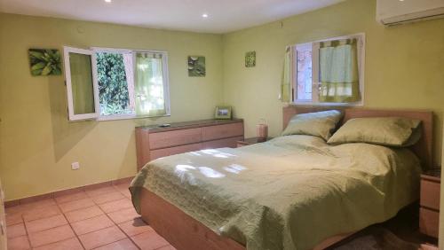 une chambre avec un lit et deux fenêtres dans l'établissement villa provençale avec piscine,proche mer, à La Ciotat