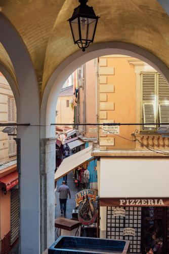 Une allée avec des arches dans une ville avec un homme marcher dans la rue dans l'établissement Le Central by EnjoyNice, 3-bed, sea at 10 min, à Nice