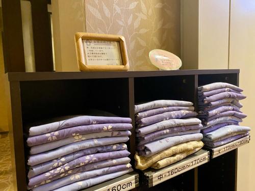 a shelf filled with lots of purple pillows at Ogoto Onsen Yunoyado Komolebi in Otsu