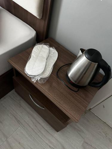 a tea kettle on a table next to a bed at Butik Apart in Tekirdag