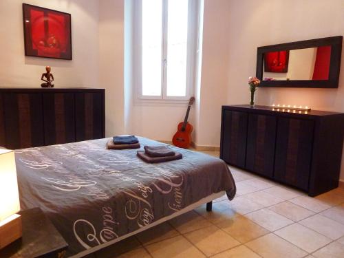 - une chambre avec un lit, un miroir et une guitare dans l'établissement Le Central by EnjoyNice, 3-bed, sea at 10 min, à Nice