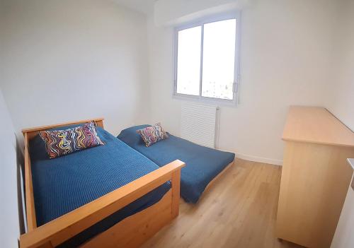 une petite chambre avec un lit et une fenêtre dans l'établissement Duplex face à la gare Arcachon, à Arcachon
