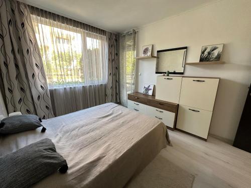 ein Schlafzimmer mit einem Bett, einer Kommode und einem Fenster in der Unterkunft Apartment in Sveti Vlas in Sweti Wlas