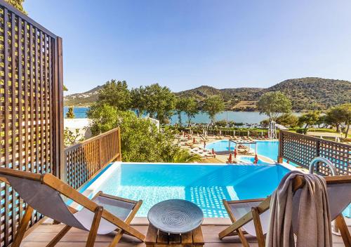 a view of a swimming pool with chairs and a table at Dolce by Wyndham Athens Attica Riviera in Vravrona