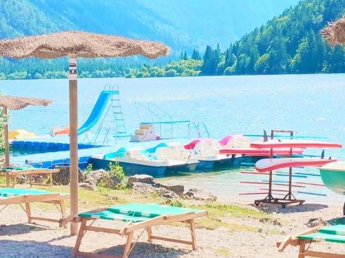 a beach with umbrellas and boats in the water at Casa JOY in Sella Nevea