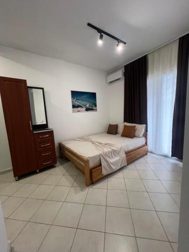 a bedroom with a bed and a dresser and a mirror at Hotel PEJA in Velipojë