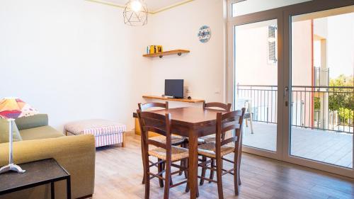 a living room with a table and chairs and a balcony at Teuladamar by Rentbeat in SantʼAnna Arresi