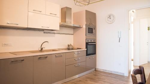 a kitchen with white cabinets and a clock on the wall at Teuladamar by Rentbeat in SantʼAnna Arresi