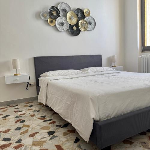 a bedroom with a large bed with plates on the wall at Ottantas Apartment in Spinazzola