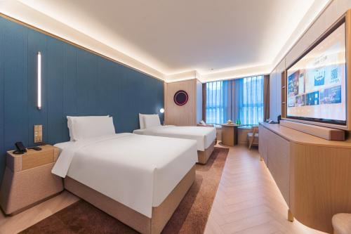 A bed or beds in a room at 北京丽泽商务区万丰路桔子水晶酒店