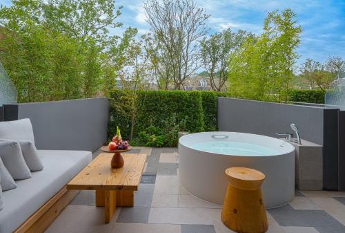 a bath tub sitting on top of a patio at Chengdu Expo Waterfall Hotel - MGallery Collection in Chengdu