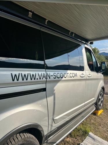 une camionnette blanche avec une tente sur le côté dans l'établissement Van&scoot, à Belgodère